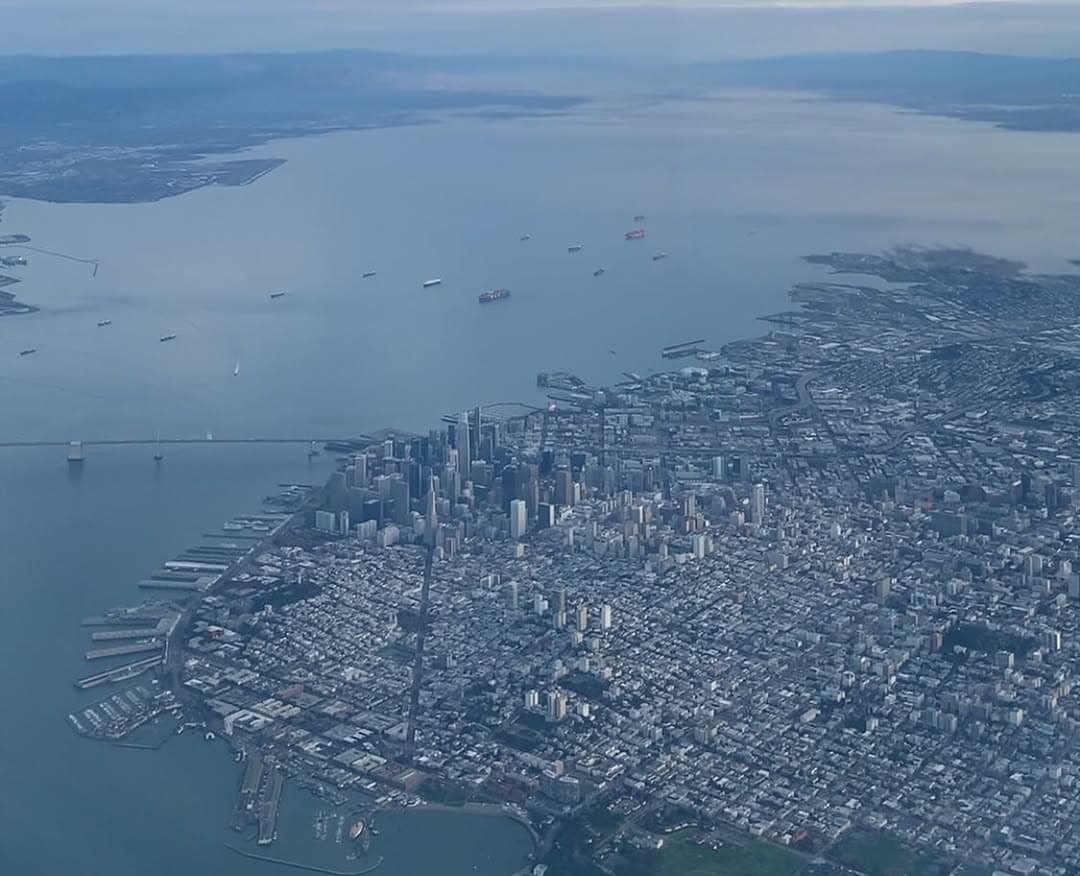 The city of San Francisco and the Bay Bridge viewed from an airplane window